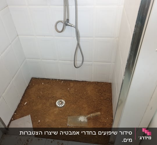 מקלחת בשיפוץ עם חול וכלי עבודה